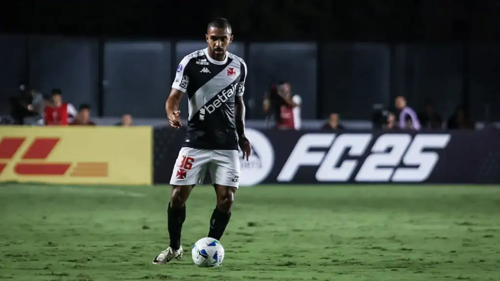 Jogador do Vasco controlando a bola no campo.