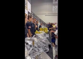 Grupo de pessoas recebendo alimentos embalados.