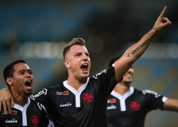 Jogador comemorando gol com amigos no estádio.