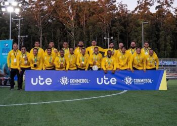 Jogadores do time posando no campo de futebol.