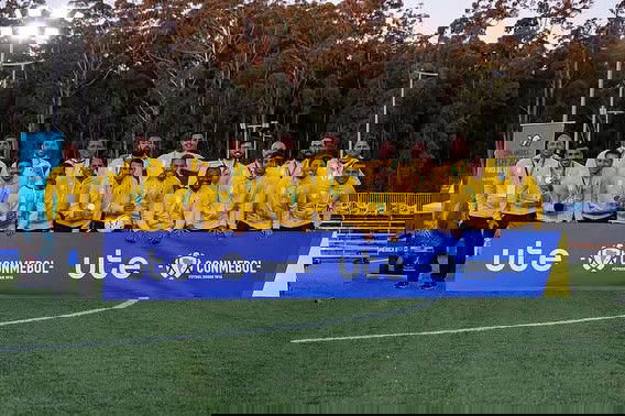 Jogadores do time posando no campo de futebol.