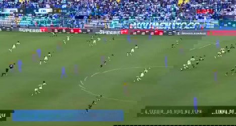 Jogadores em campo durante partida de futebol.