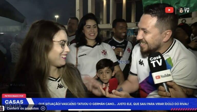 Ao vivo torcida do Vasco comemorando encontro com jogador, todos sorrindo em evento esportivo.