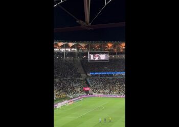 Estádio de futebol lotado durante o jogo.