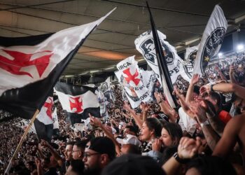 Bandeiras do Vasco sendo agitadas na torcida.