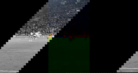 Jogadores em campo durante partida de futebol.