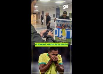 Paciente com expressão de tristeza segurando a boca, na frente de um balcão.