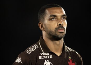 Vasco atacante com uniforme do time, fundo preto.