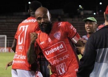 Vasco jogando com torcedores comemorando na torcida.