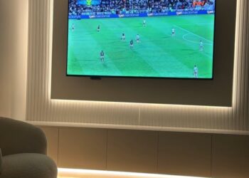 Goleiro assistindo jogo na TV com bebê virtual vestido de vascaíno.