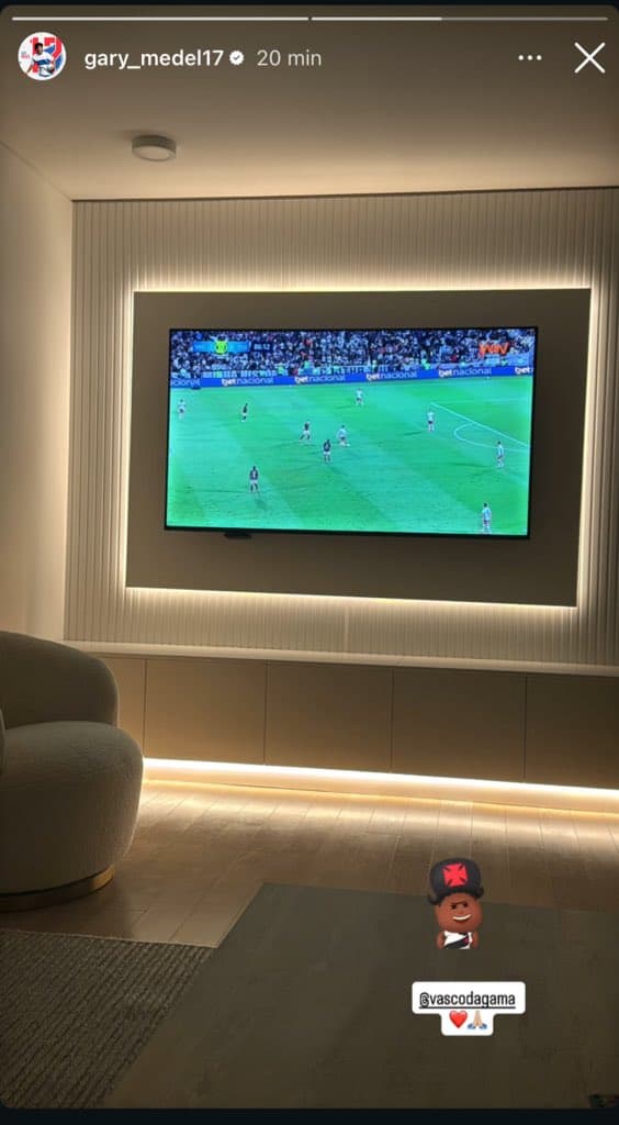 Goleiro assistindo jogo na TV com bebê virtual vestido de vascaíno.