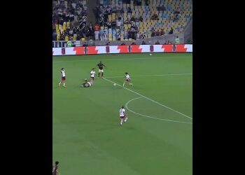 Jogadores de futebol em campo durante partida vibrante.