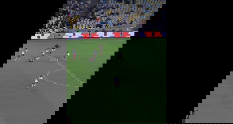 Jogadores de futebol em campo durante partida vibrante.