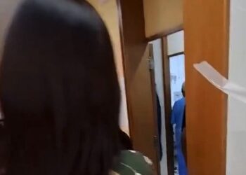 Homem entrando em sala com porta aberta.
