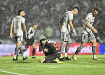 Vasco treinando na chuva durante partida.