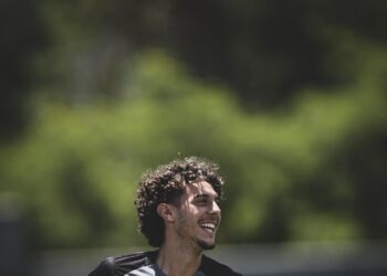 Jovem jogador do Vasco correndo com camisa de desporto.