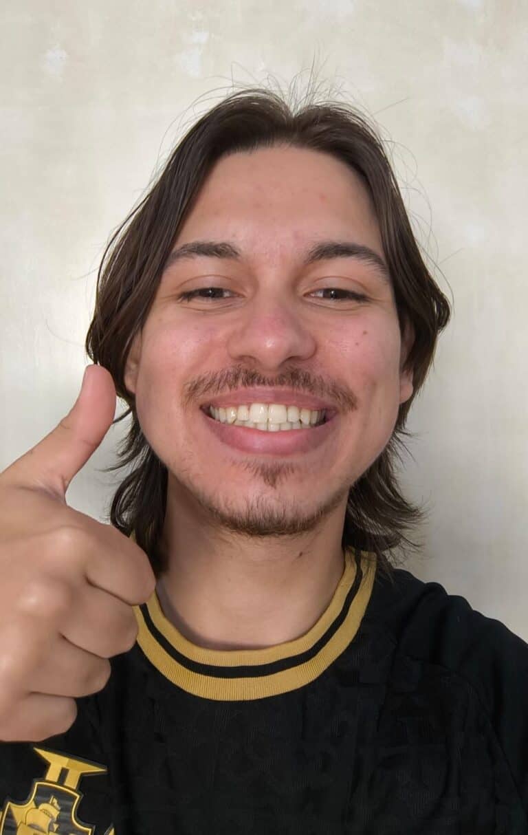 Vasco fan sorrindo com uniforme, dedo apontando, fundo liso.