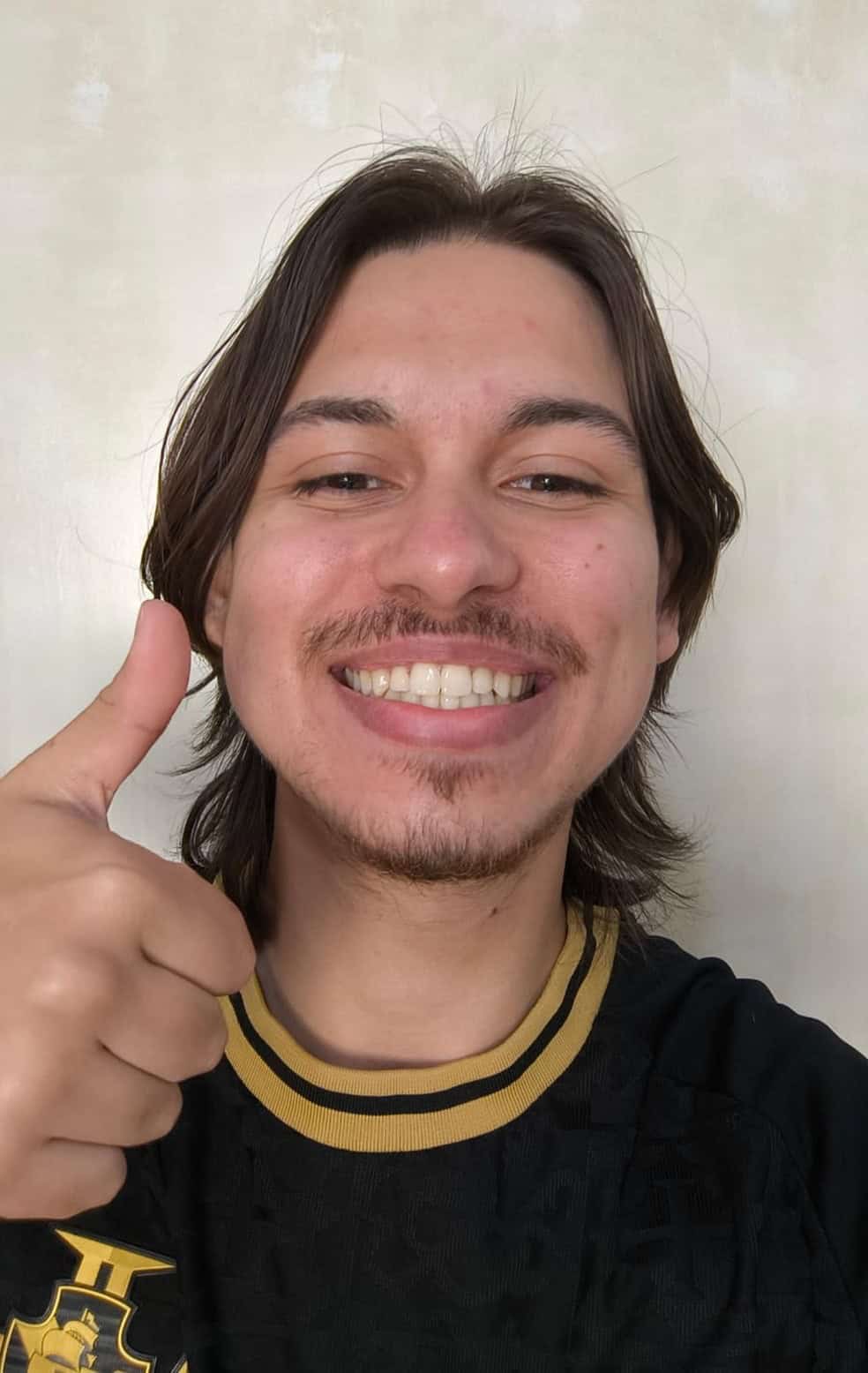 Vasco fan sorrindo com uniforme, dedo apontando, fundo liso.