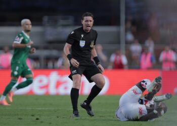 Árbitro de futebol expulsando jogador no campo.