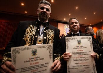 Aproveitamento de exemplo com uma foto de dois homenageados em cerimônia.