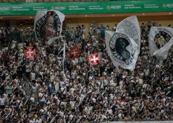 Vasco da Gama torcedores com bandeiras e uniformes pretos e brancos.