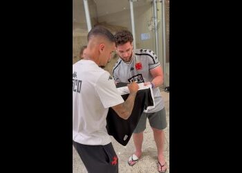 Atleta do Vasco assinando camisa.
