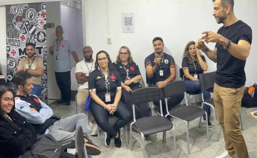 Vasco fan club members listening to speaker in room.