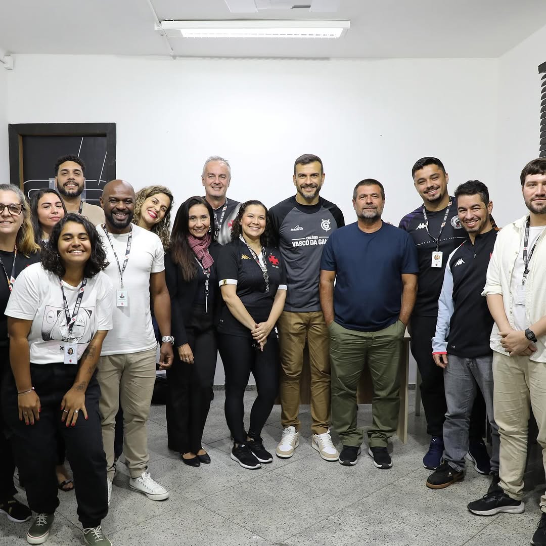 20251026-111837-1-9 Arquivo de grupo de pessoas sorrindo em ambiente interno.