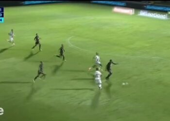 Jogadores em campo durante partida de futebol.