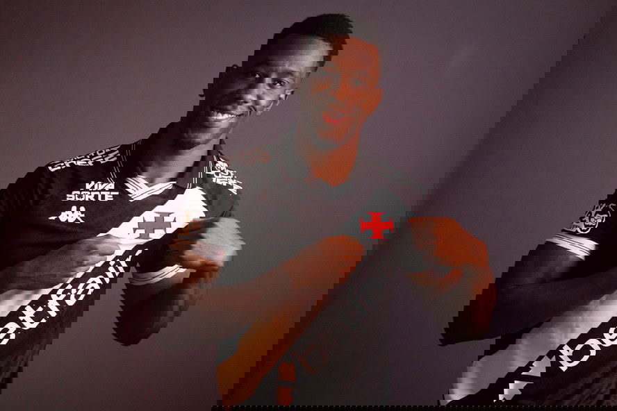 Jogador do Vasco segurando a camisa do time.