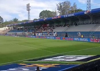 Estádio de futebol vazio com gramado bem cuidado.