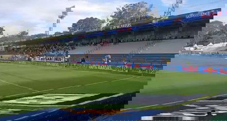 Estádio de futebol vazio com gramado bem cuidado.