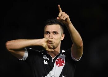 Homem comemorando gol com gesto de silêncio.