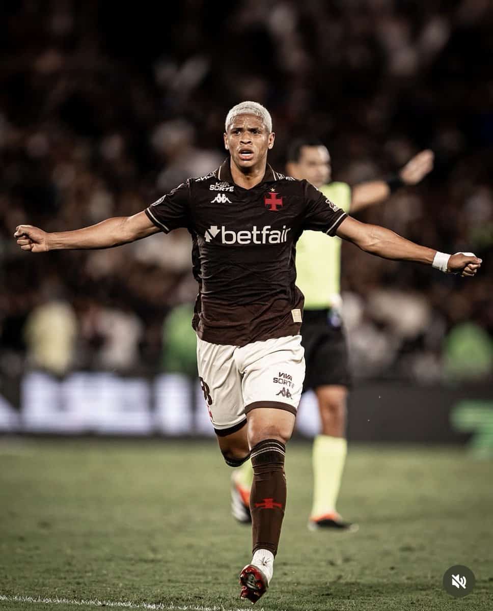 20251026-203711-1-1-1-1 Jogador de futebol comemorando gol em campo.