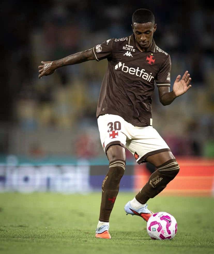 30, jogador do Vasco de uniforme jogando futebol em campo, chute na bola, estádio ao fundo.