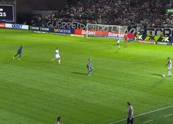 Jogadores em campo durante partida de futebol.