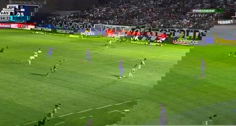 Jogadores em campo durante partida de futebol.