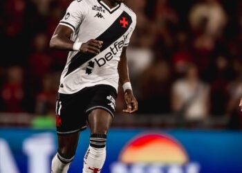 Jogador de futebol em ação com a bola nos pés.