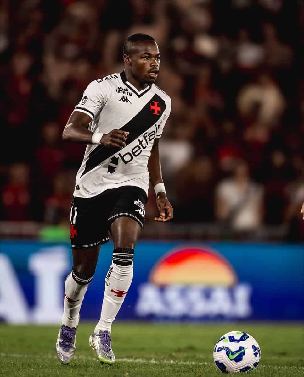 Jogador de futebol em ação com a bola nos pés.