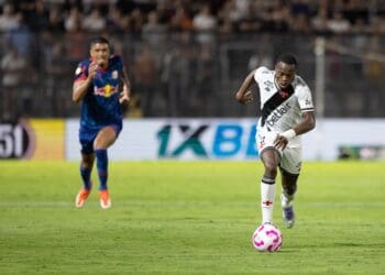 Jogador do Vasco chuta a bola em campo.