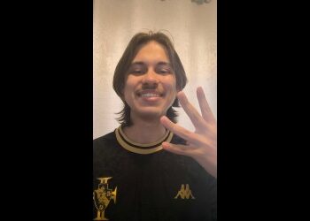 Jovem sorrindo com uniforme do Vasco.