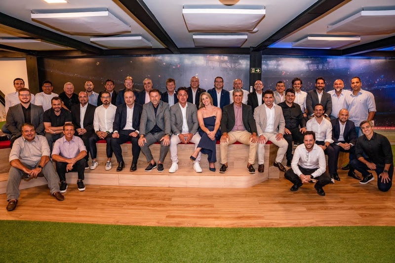 20251028-183631-1-dirigentes-posam-durante-encontro-da-lfu-na-sede-da-livemode-no-rio-de-janeiro-rj-no-final-de-fevereiro-rafael-brito-divulgacao-1 Grupo de pessoas em evento formal no interior de um espaço moderno.