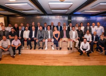 - Uma grande reunião de profissionais do Vasco em ambiente interno moderno.