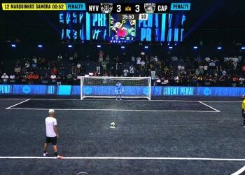 Jogador se preparando para cobrança de pênalti no estádio.