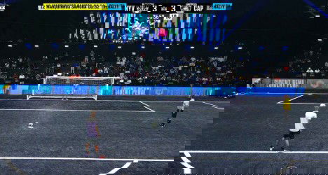 Jogador se preparando para cobrança de pênalti no estádio.