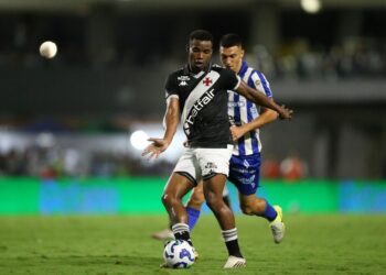 Jogador do Vasco controlando a bola em campo.
