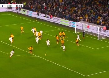 Jogadores em ação durante partida de futebol no campo.