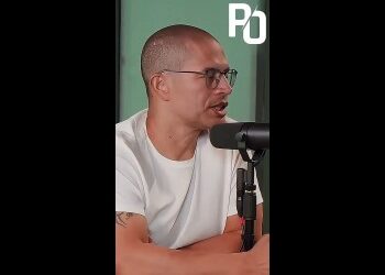 Homem falando em microfone em estúdio.