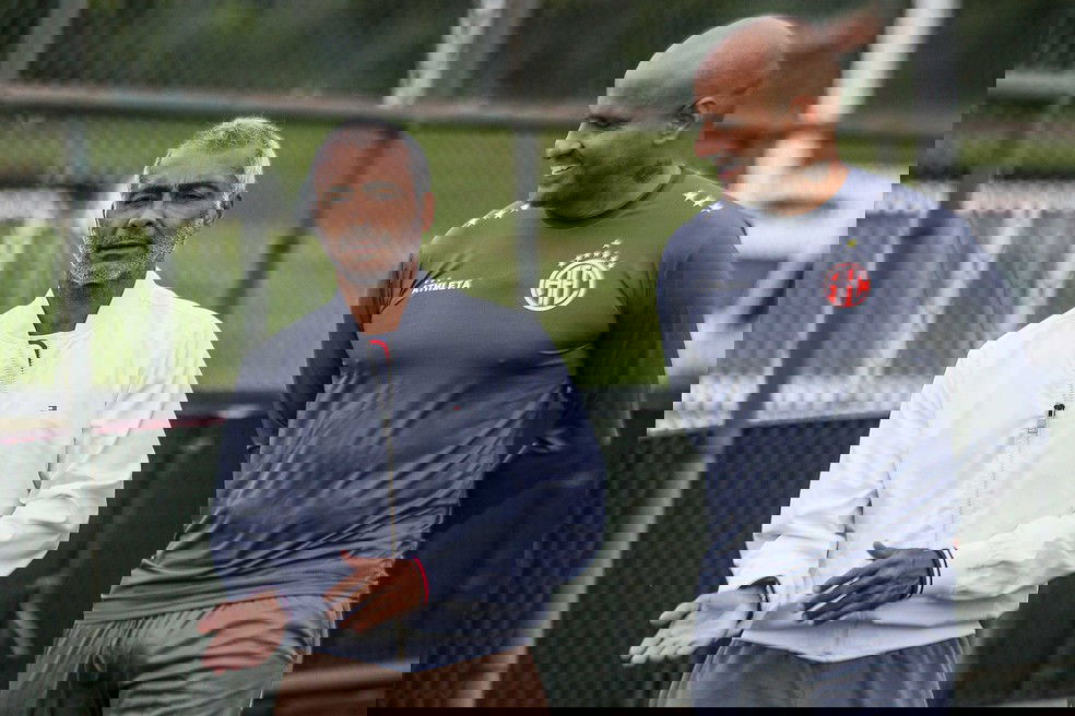 20251030-121514-1-74-romario-presidente-do-america-e-bruno-reis-gerente-de-futebol-foto-joao-carlos-gomes Homem idoso conversando com atleta de futebol no campo.