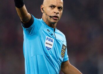 Árbitro de futebol com uniforme azul.